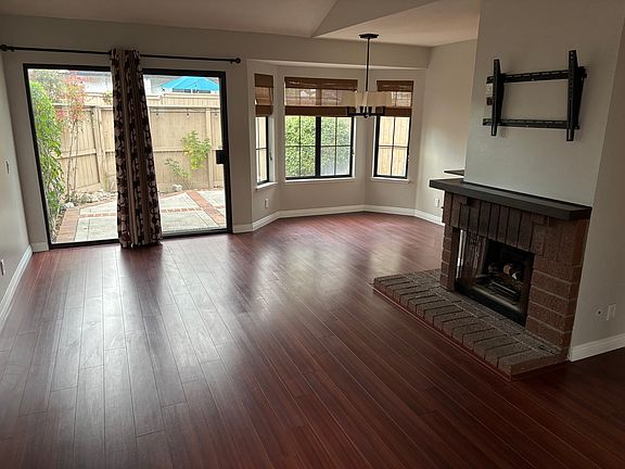 Living room, fireplace with TV mount above, dining area