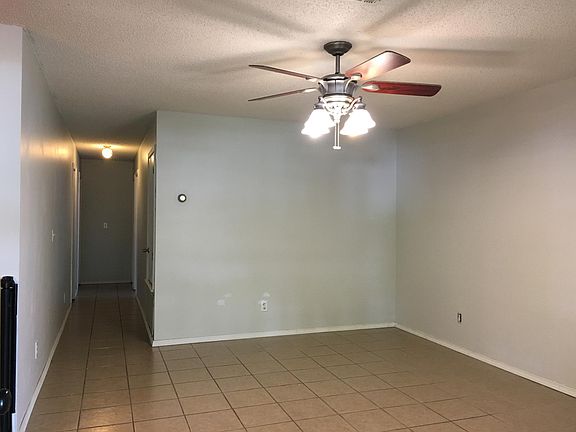 Living room with ceiling fan and tile throughout