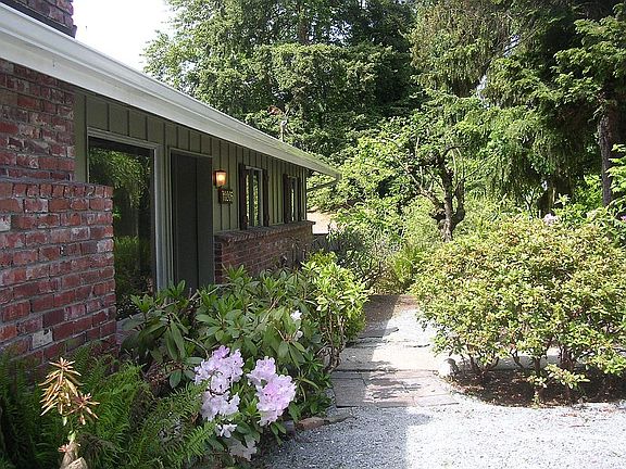Looking north along front of house with view of garden, trees, and path