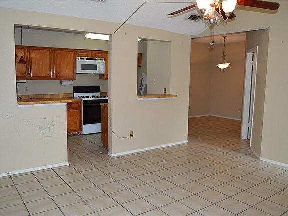 Tile living area with cathedral ceiling open to kitchen.