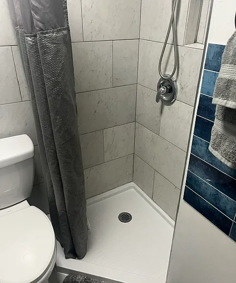 Shower with new curtain and drain pan.