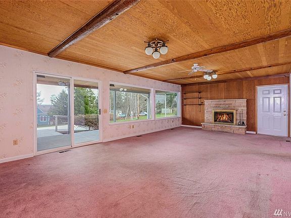 Spacious living room with wood burning fireplace.