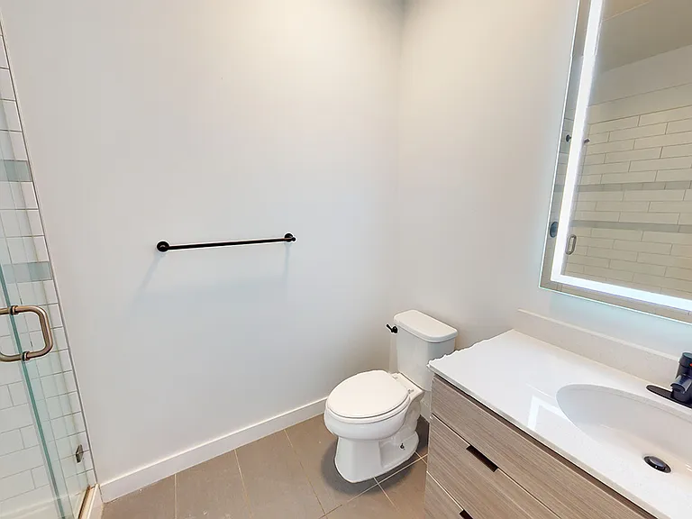 Apartment bathroom with tile flooring.