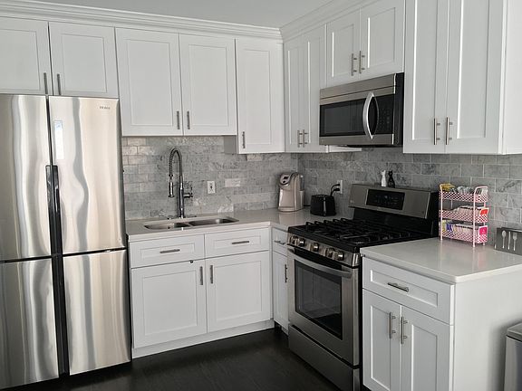 Quartz countertops, stainless steel applicances, stone backsplash, and soft close cabinets