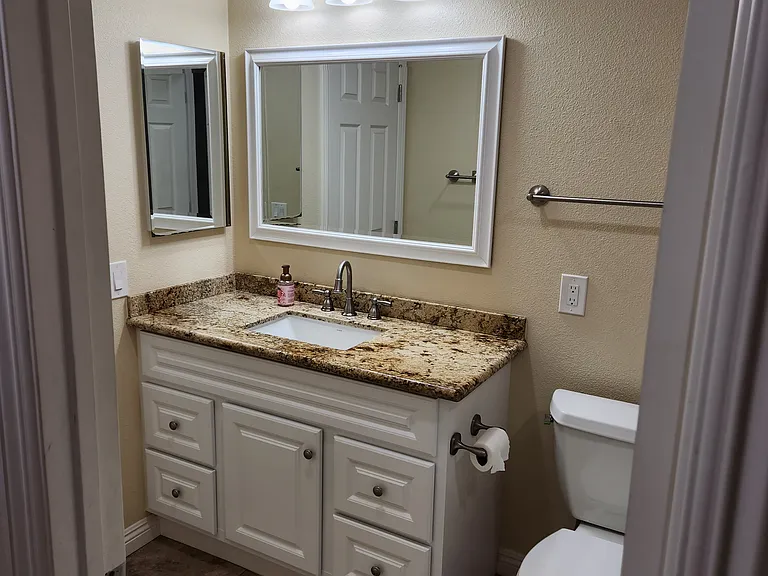 Full bathroom with bathtub and door connecting to second bedroom.