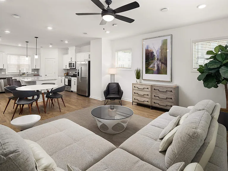 View of the living room area featuring an open staircase and refined dining space.