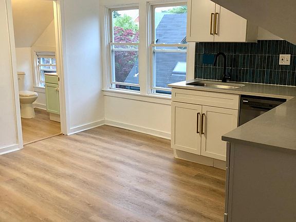 Bright new cabinets, accented with modern gold pulls, look dazzling against the designer tile backsplash and new quartz countertops. Stainless dishwasher for easy clean also included.