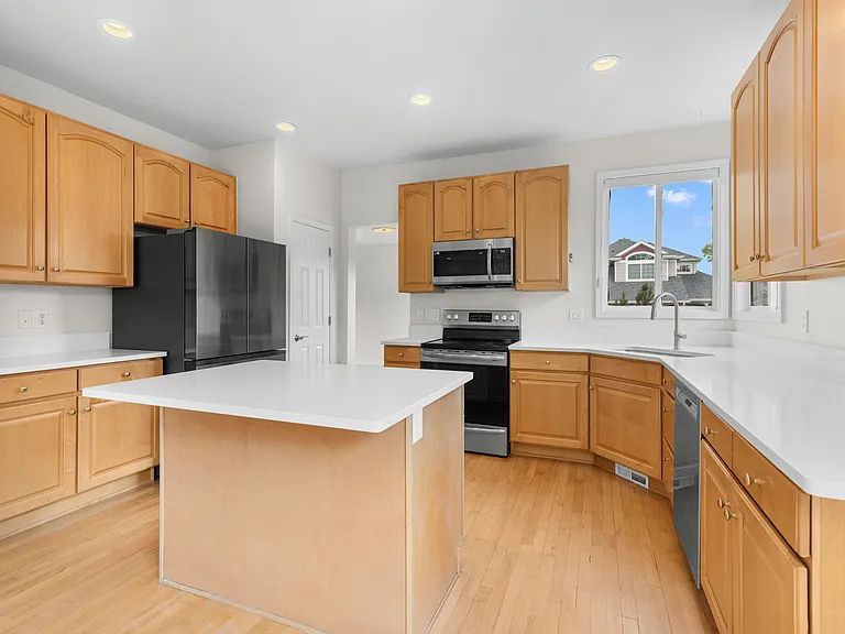The kitchen has been thoughtfully updated with new quartz countertops, and a new refrigerator, microwave, sink, and faucet.