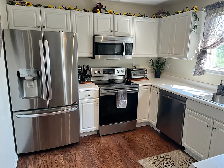 Kitchen has newer appliances and a view of the backyard