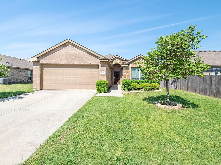 Ranch-style home featuring brick siding, driveway, and a garage