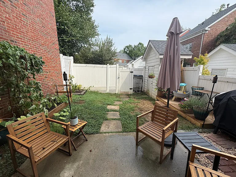 View from back door through backyard to outer fence (and parking spot behind that)