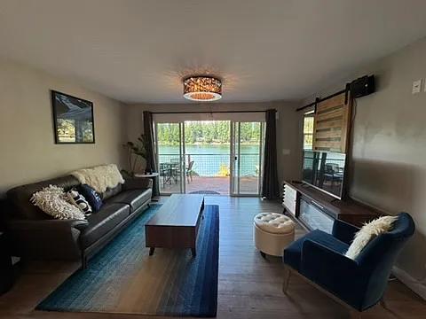 Living room with lake front view, electric fireplace and TV