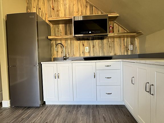 Kitchen with convention/microwave oven and state of the art range top burner plate. Appliances are all new.