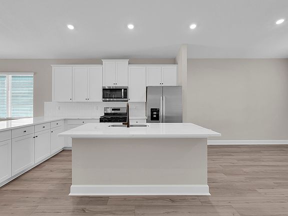 The spacious kitchen, complete with a large island, offers plenty of room for cooking and gathering.