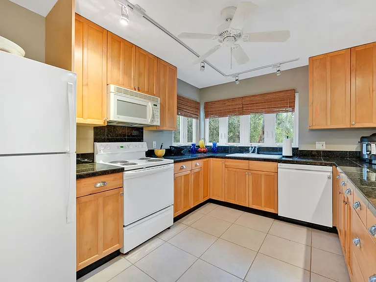 Corner windows in full Kitchen with electric stove, microwave hood, dishwasher, garbage disposer & refrigerator. Pots, pans, dishware & utensils are provided. Stacked laundry included.
