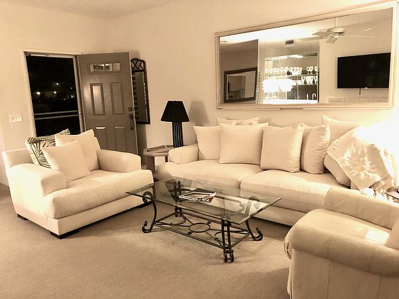 Stylish living room with deep seats on the comfortable couch and chair, with an additional leather lounge chair to enjoy the large, flat panel smart TV.