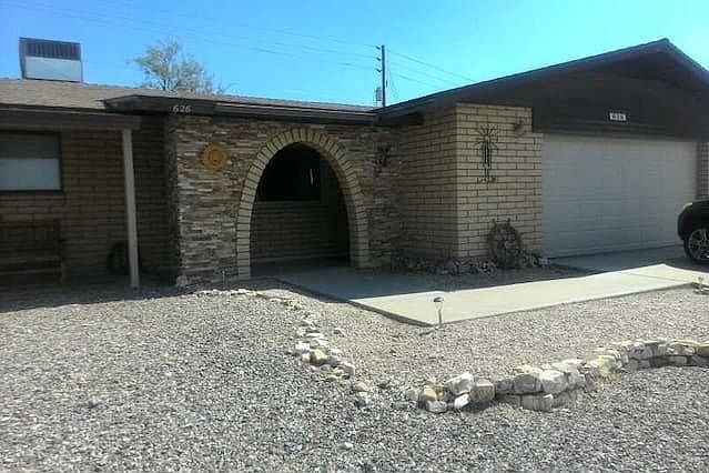 slump stone home with ledger stone around the arch