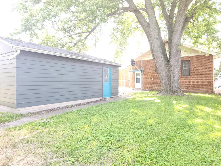 View of the garage and house taken from the back yard.