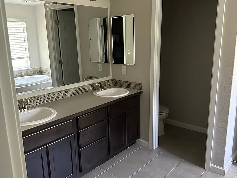 Primary ensuite bathroom. 2 sink vanity, separate toilet room.