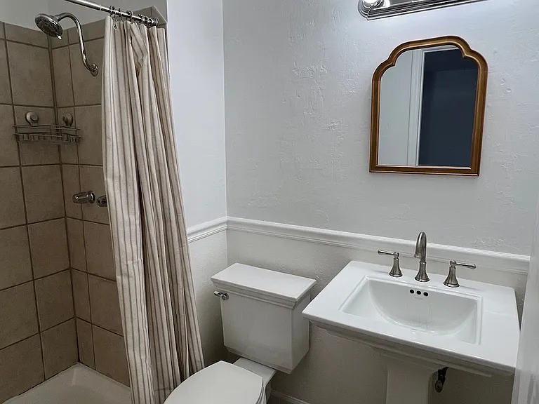 Primary bedroom full-bathroom. New hardware and shower. Medicine cabinet with storage behind the door.