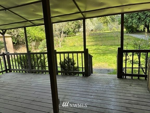 Back covered deck with partially fenced yard.