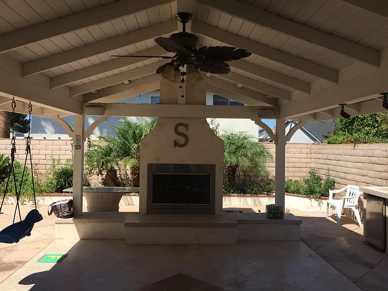 Covered backyard patio with custom BBQ.