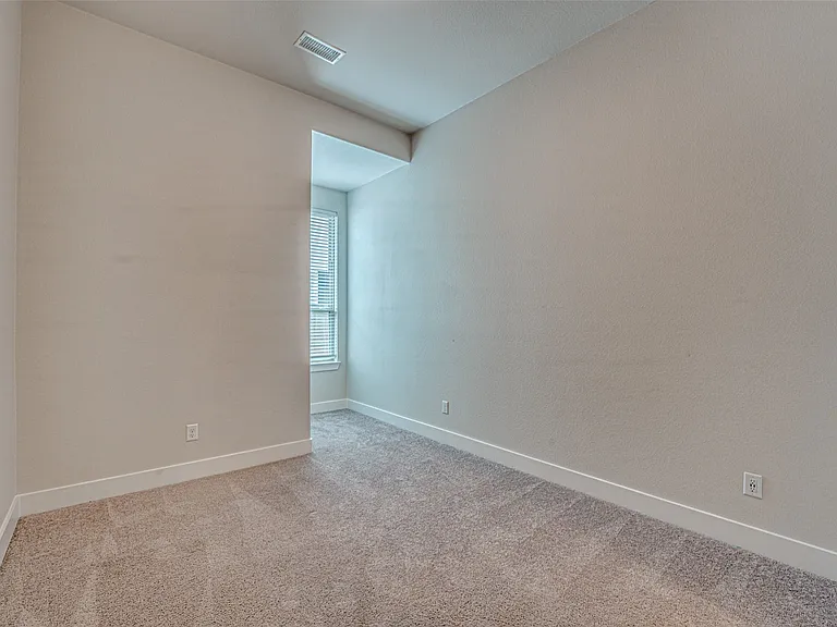 Carpeted interior space with neutral wall paint and white baseboards