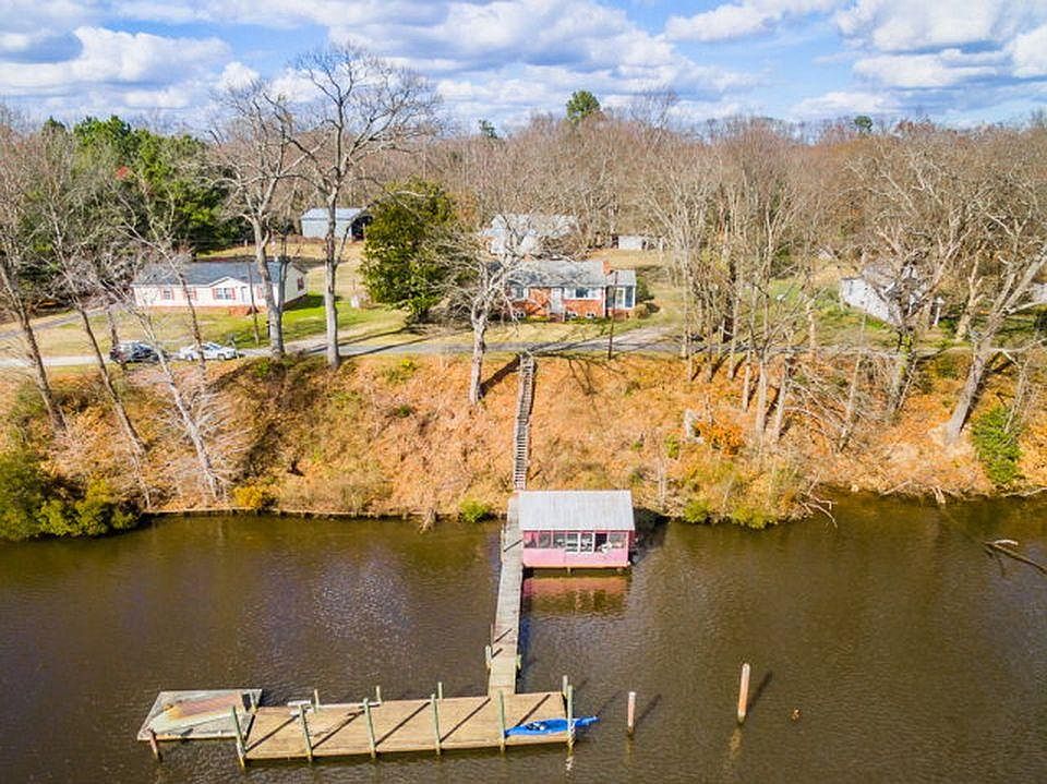 Aerial view of the property, the dock, and river "house"