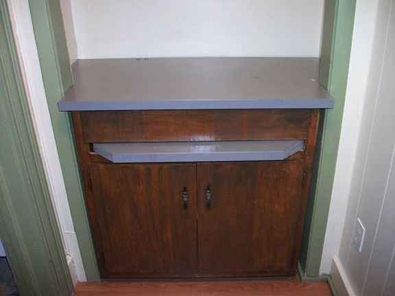 cupbaoard in alcove with pull out shelf. Great for microwave or computer.