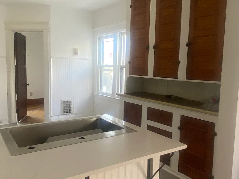 Two seats are available at the breakfast bar behind the sink.