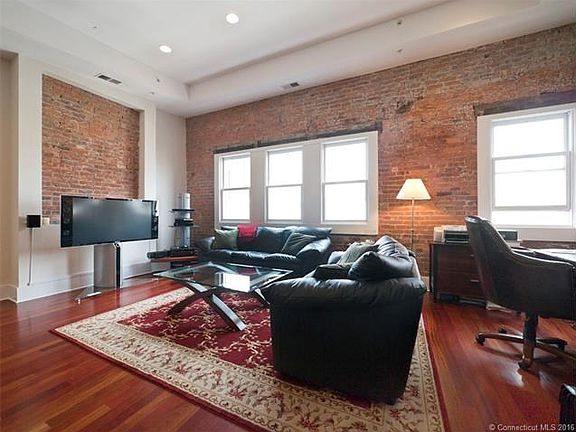 Living room with exposed brick + 14 ft vaulted ceiling