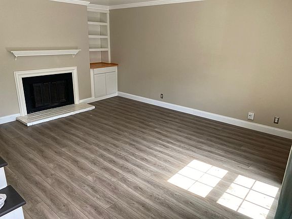 Living room with built-ins and wood-burning fireplace