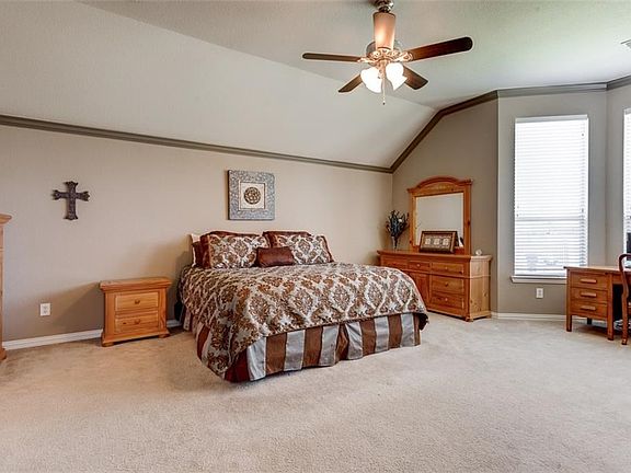 Large Master Suite with vaulted ceiling, crown molding, bay window and ceiling fan.