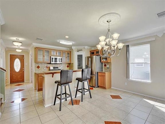 Ceramic tile throughout the entry, kitchen, dining and powder bath. Updated lighting throughout. Crown molding in abundance!