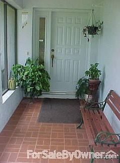 Front Porch : Front entrance to Vestibule. Covered ceiling, screened-in with tiled floor.
