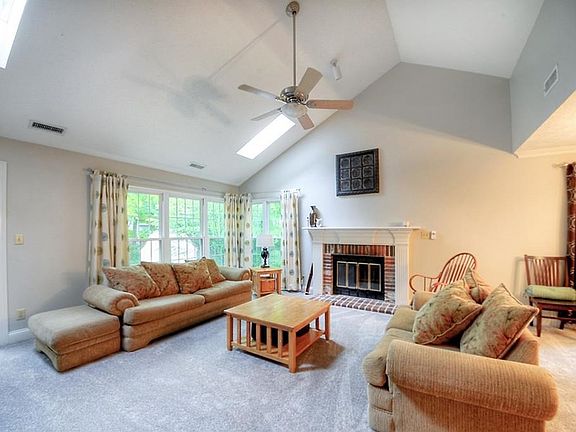 Great Room with cathedral ceiling, fan, and fireplace