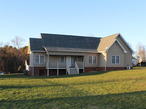 BACK OF HOME WITH PORCH/ DECK. ON HALF ACRE