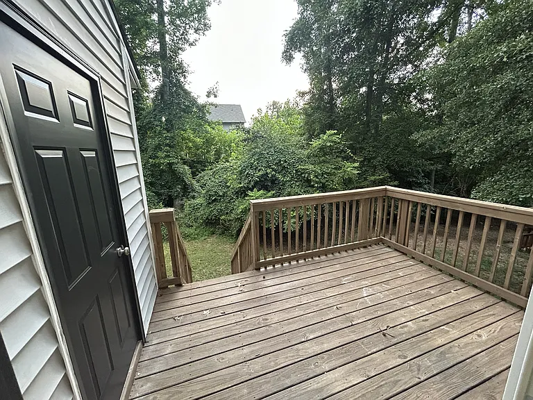 Back deck with stairs leading down to yard. Exterior storage closet to left.
