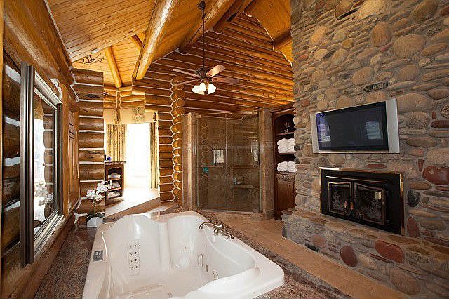 River stone fireplace adds texture to log interior