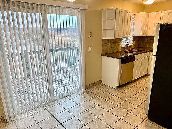 View of kitchen, dinette, and patio door to large deck.