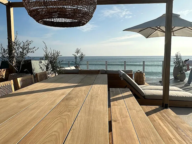Savor meals outdoors on the rustic wooden table_a perfect spot for coastal dining.