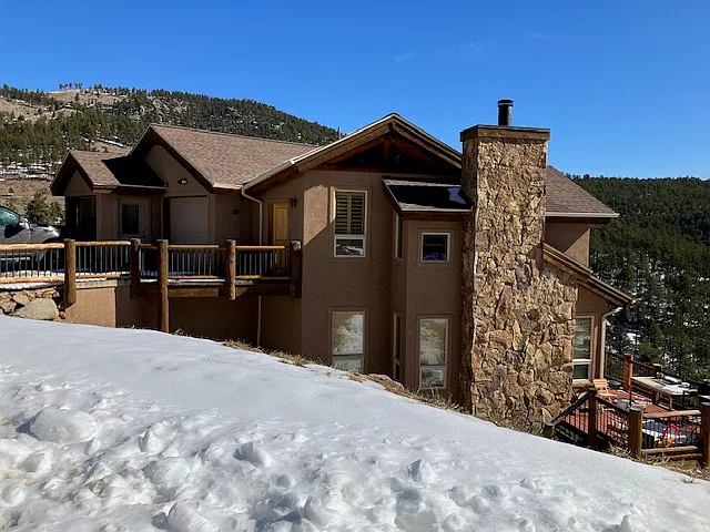 View of home from the road in the winter. Your section is the walkout basement under the deck that faces the mountain view.
