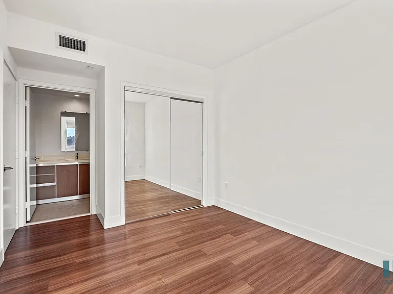 Bedroom with Bathroom, Mirrored Closet, and Vinyl Flooring