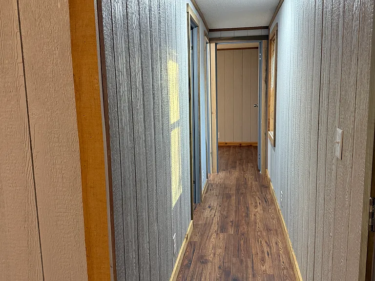 Hallway from living room to other two bedrooms and three-quarter bathroom.