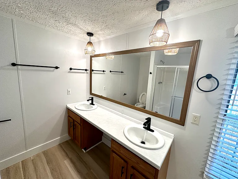 Primary Bathroom with double vanity, shower and tub. New toilet, plumbing and light fixtures, and window blinds.