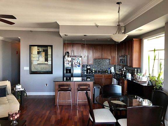 Kitchen with custom backsplash, granite countertops, and cabinet lighting.