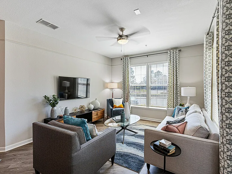 Ceiling fan and ample natural lighting in apartment living rooms at The Savoy at Southwood