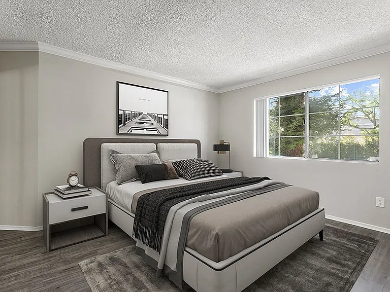Carpeted bedroom with large window for natural light.