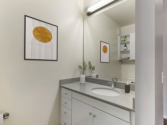 Renovated Package I bath with dark quartz countertops, white cabinetry, and hard surface flooring