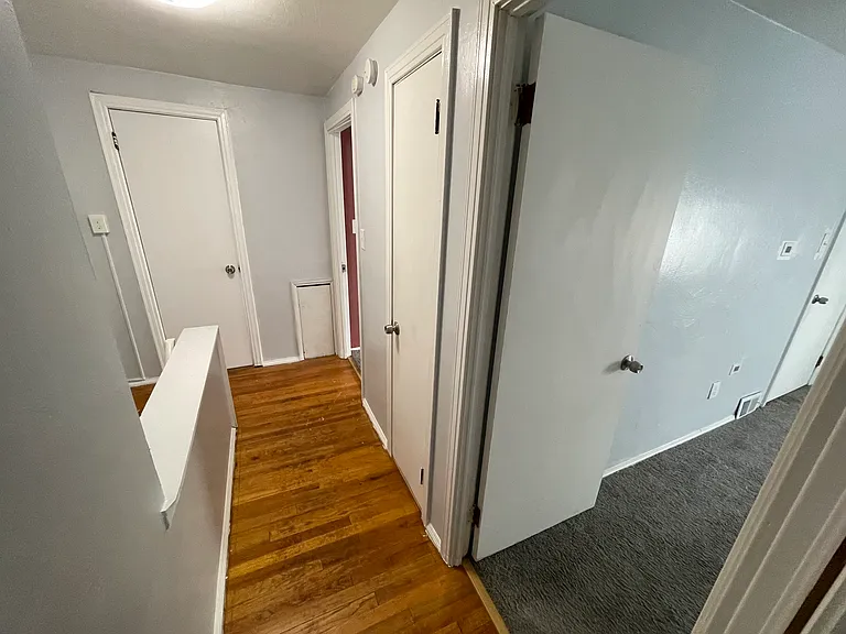 View of the bathroom door (left), 1st bath, shared closet, primary bedroom (3rd bedroom behind camera)